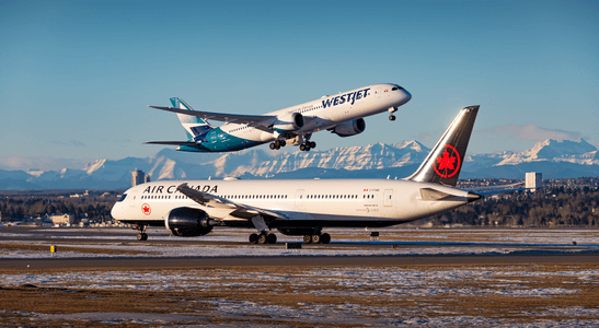 Two airplanes, one from Westjet and another from Air Canada, on a runway with mountains in the background.