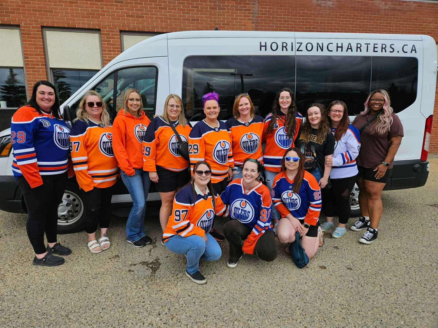Group of people travelling to bike and beer ride in front of a van with 'Horizon Charters' logo.