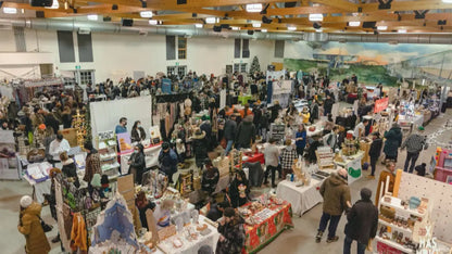 Large indoor market with numerous stalls and people browsing.