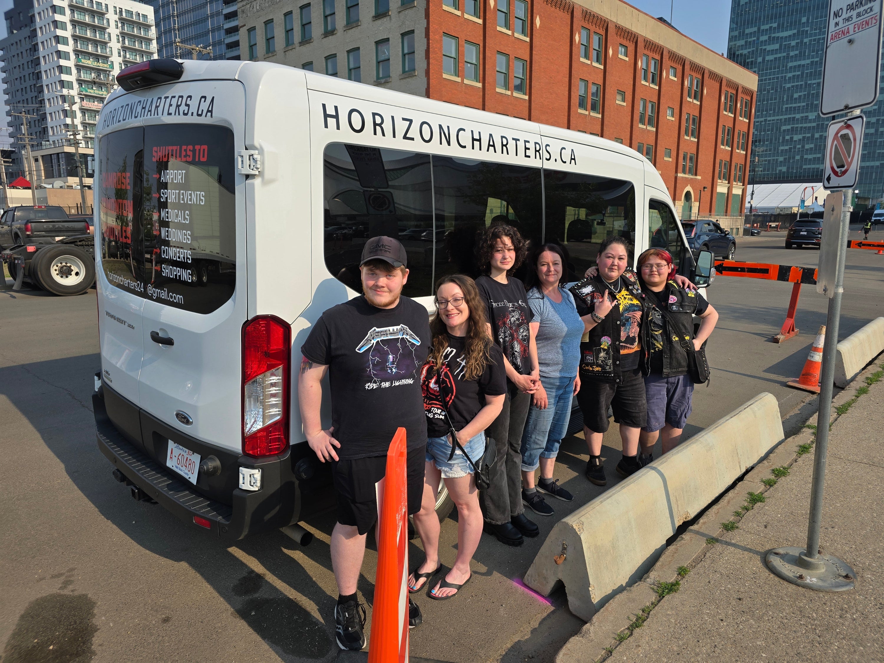 Group of people standing in front of  'HorizonCharters.ca' Shuttle Van branding on a city street.