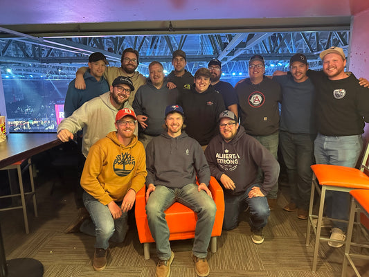 Group of people posing together in a room with sports-themed decor